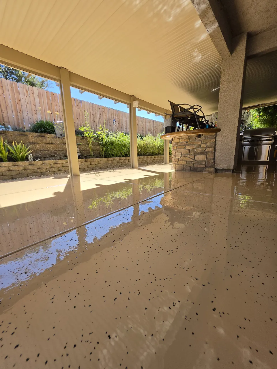 Beige epoxy and black flake floor from the far end of the covered patio