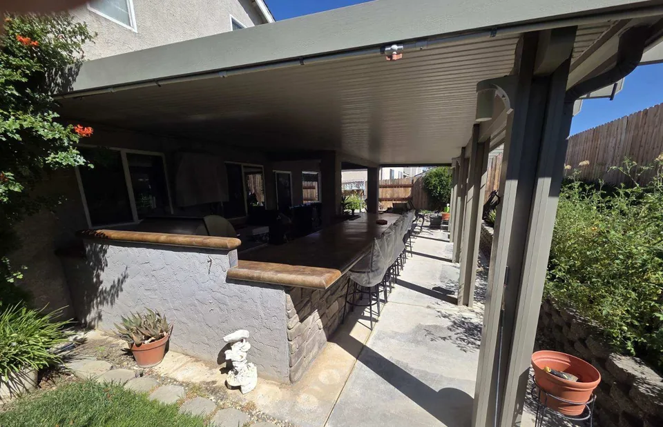 Before: the covered patio and outdoor kitchen with the old coating